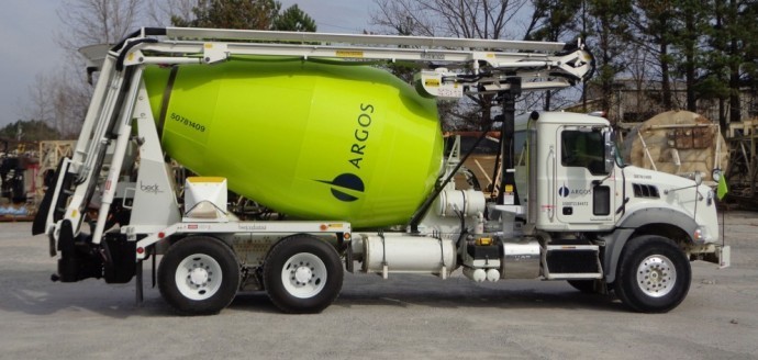 A green truck with a cement mixer attached to it.