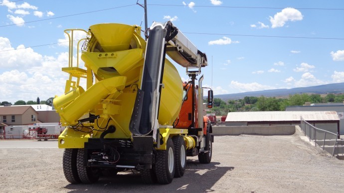 A yellow concrete mixer truck parked in a parking lot.