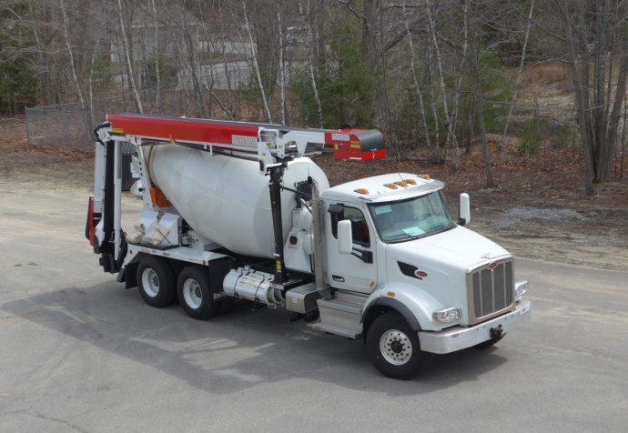 A cement mixer truck is parked in a parking lot.