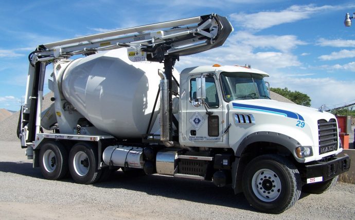 A white truck with a cement mixer attached to it.