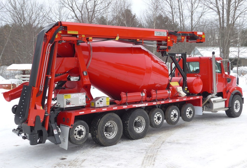 A red truck with a concrete mixer on it.