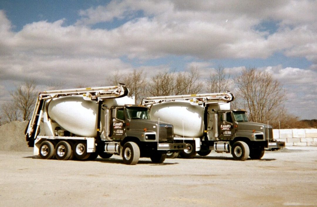 Two cement trucks parked in a parking lot.
