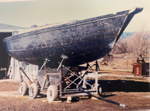 Steel-hulled sailboat under construction on a trailer